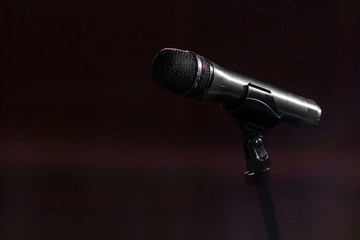 Obraz premium The microphone is on the counter against a dark cherry color. Copy space.