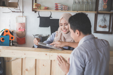 female waitress showing the menu to her customer