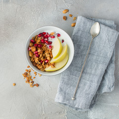 Healthy breakfast. Granola with with pomegranate, green apple and yoghurt in glasses on concrete background. Fresh berries, fresh fruits, homemade granola. Country style. Rustic style. Place for text