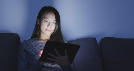 Woman using tablet at home in the evening