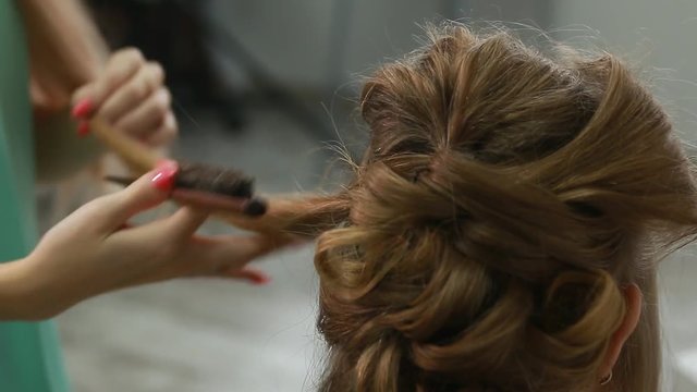 Professional Hair Dresser Used Hair Curler Iron for brunette Hair at beauty salon