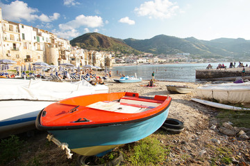 Fototapeta premium CEFALU, ITALY - OCTOBER 1, 2017: Small and beatufiul Cefalu bay with red boat in the foreground