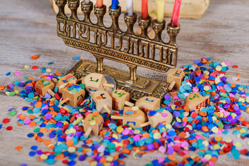 Image of jewish holiday Hanukkah with wooden dreidel spinning top on the glitter background