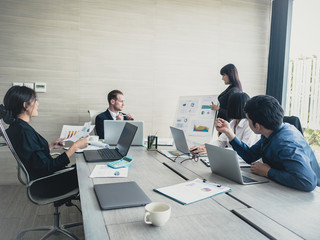 Fototapeta premium Asian Business Woman presenting her work with team at the meeting room, People working Concept. Vintage tone.