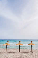 Straw umbrellas on sand beach.