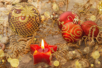 Festive candle with Christmas red and gold balls. Golden christmas background, greeting card