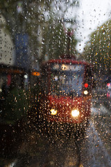 Glass with rain drops, the glass visible red tram