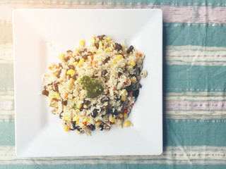 fried rice with vegetable in white dish on fabric background , vegan or vegetarian food. Thai...