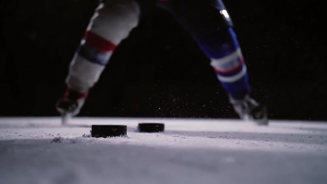 Professional hockey player produces a shot on goal at ice arena. Close-up. Slow motion