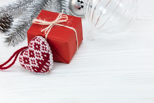 handmade present box with decorative heart, christmas tree decorations on white wooden boards