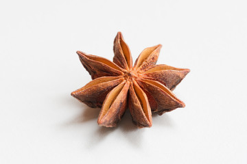 Star anise spice fruit and seeds on a white surface