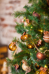 Golden and brown balls on the Christmas tree. Close-up