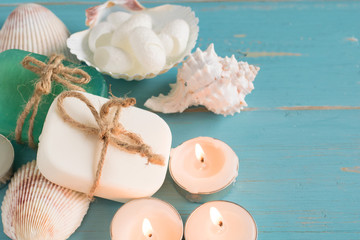ocean blue spa products soap candle compress herbal ball and silk cocoon for scrub  on blue wood background with copy space , ocean breeze fresh aroma concept