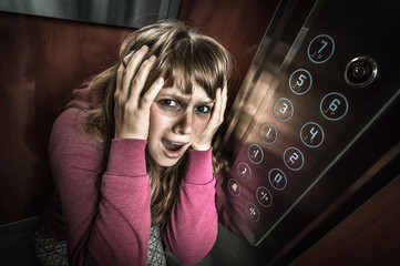 Shocked woman with claustrophobia in the moving elevator - obrazy, fototapety, plakaty