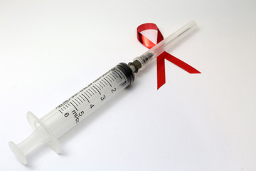 syringe and red ribbon on white background