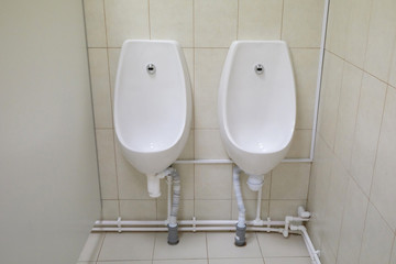 two urinals in a public toilet