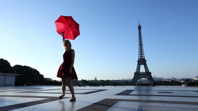 travel to Paris, silhouette of beautiful girl dancing with red umbrella near Eiffel Tower
