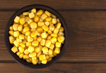 Canned corn  in a bowl on old wooden table