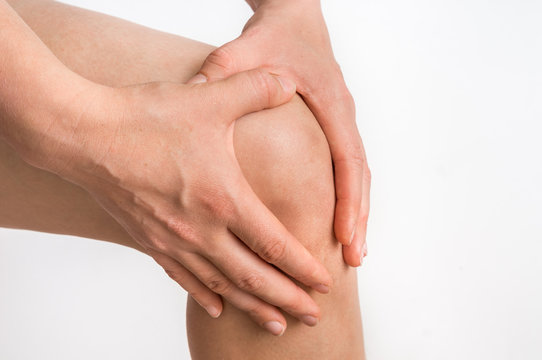 Woman with knee pain is holding her aching leg