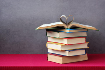 Open book with curled leaves in the shape of a heart.