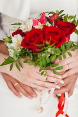 Wedding bouquet of roses in bride's hands closeup