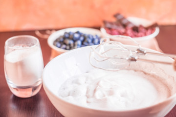Whipped egg whites for meringue. Mixing white egg cream in bowl with motor mixer, baking cake. Anna Pavlova meringue. Whipped egg whites and sugar powder. Baking dessert concept