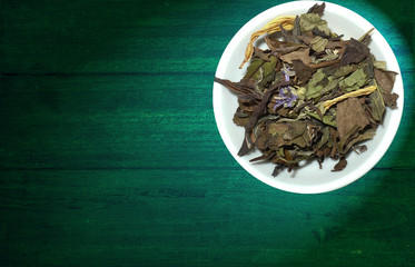 variety of tea in strands and coffee beans on rustic wooden background