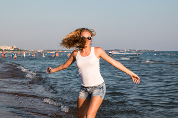 Blond teenager girl on the beach near sea