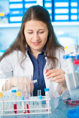 Young female technician in genetic laboratory with PCR