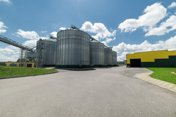 The modern granary. High metal silos for storage of wheat and barley. Sunny day, the blue sky.