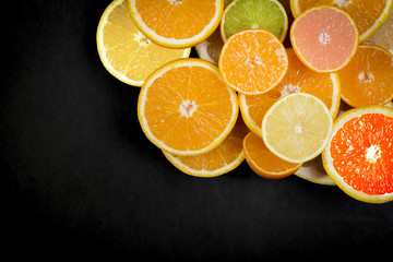 Citrus fruits (orange, lemon, grapefruit, mandarin, lime) on the dark background. Fruit food background. Fresh citrus fruit assortment