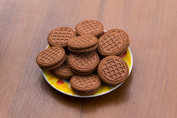 Chocolate cookies with cream filling on wooden table