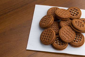 Chocolate cookies with cream filling on wooden table