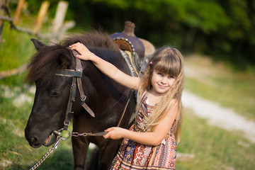 Cute fermer beautiful girl cowboy in jeans enjoying summer day in village life with flowers wearing...