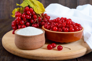 Red viburnum in a ceramic bowl, sugar, a bunch of berries for tea, jam.