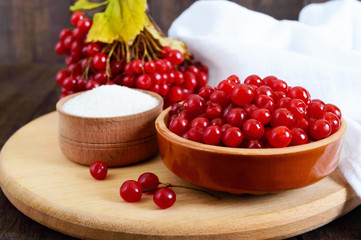 Red viburnum in a ceramic bowl, sugar, a bunch of berries for tea, jam.
