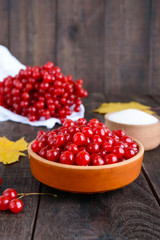 Red viburnum in a ceramic bowl, sugar, a bunch of berries for tea, jam.