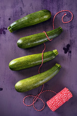 Top view of whole green zucchini over dark background. 