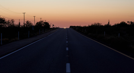 Car coming on a highway after sunset.