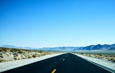 Fototapeta premium Blue landscape with black asphalt road in desert near Las Vegas