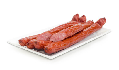 Smoked vienna sausages on white rectangular dish closeup