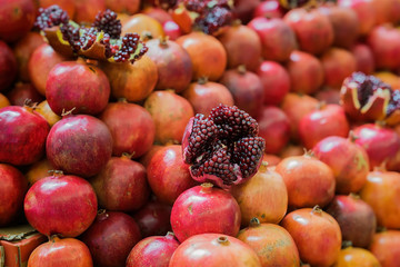 Sale of fresh of ripe juicy pomegranates, farmer's bazaar, open showcases of market. Vegetarian concept, diet, detox, organic vitamins