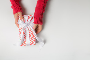 Christmas concept - hands in steater holding present