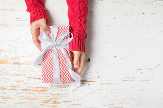 Christmas concept - hands in steater holding present