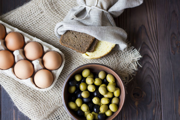 eggs, bread, olives on a wooden table