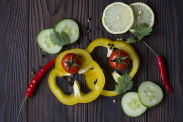 Fresh organic vegetables: tomatoes, pepper, parsley, lemon, cucumber, chili, spices on a dark wooden table