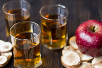 red Apple with Apple juice on a wooden table close up