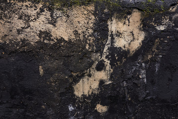 black concrete wall with stains of paint