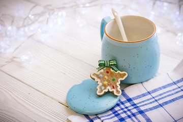 New Year's still life with open sugar bowl, white spoon, cookies, tablecloth in a box on a white wooden table, light background on a sunny day