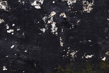 black concrete wall with stains of paint